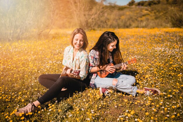 Mujeres jugando ukuleles en el suelo