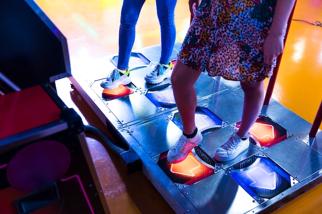 Mujeres de lado jugando arcade de baile