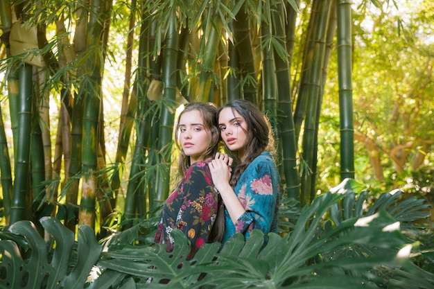 Foto gratuita mujeres de lado posando y mirando a cámara