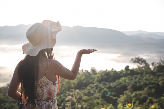 Mujeres levantando las manos en el espacio libre en las montañas