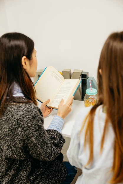 Foto gratuita mujeres leyendo libros en la mesa