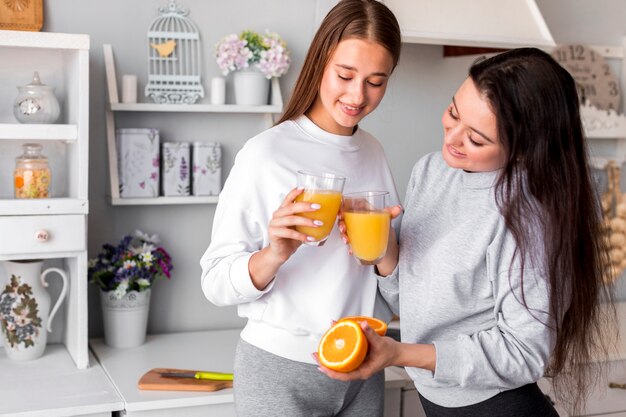 Mujeres lindas bebiendo jugo de naranja