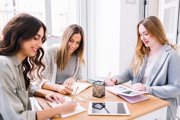 Mujeres lindas dibujando en cuadernos de dibujo