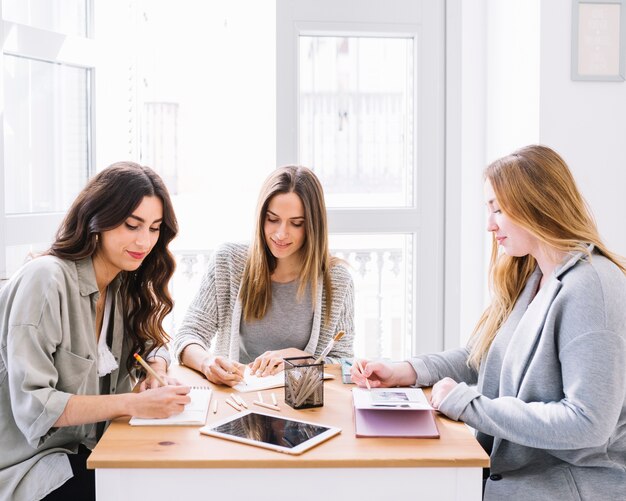 Mujeres lindas haciendo bocetos juntos