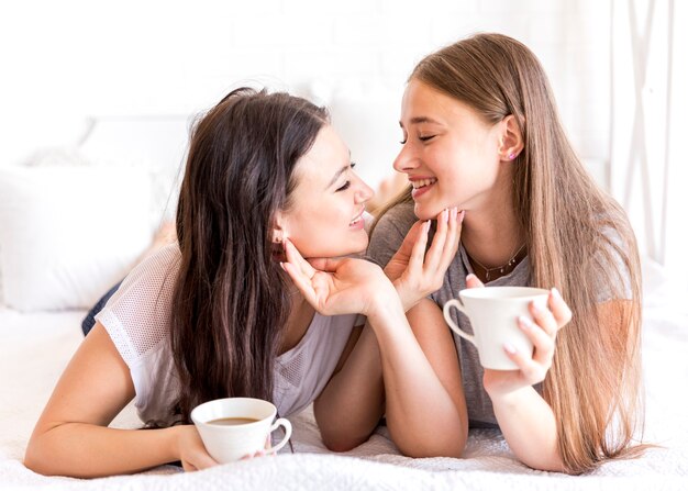 Mujeres lindas que se tocan las caras.