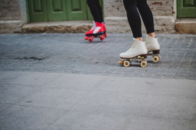 Mujeres, llevando, rollerskates, equitación, pavimento