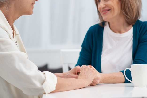 Mujeres maduras cogidos de la mano juntos