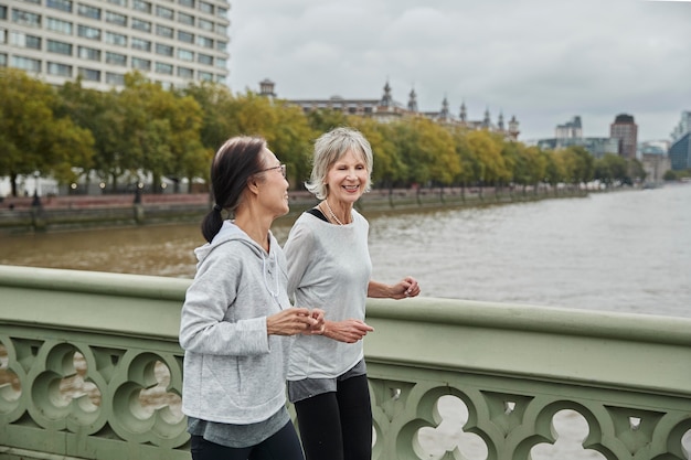 Foto gratuita mujeres mayores corriendo juntos tiro medio