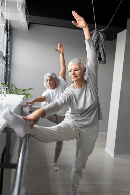 Foto gratuita mujeres mayores haciendo ejercicios de fitness en el gimnasio