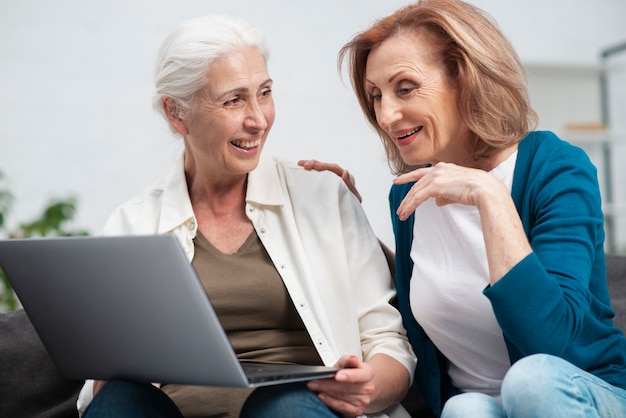 Foto gratuita mujeres mayores junto con una computadora portátil