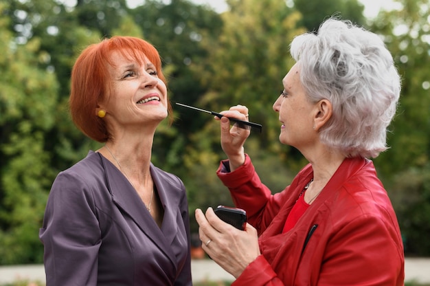 Foto gratuita mujeres mayores con maquillaje al aire libre