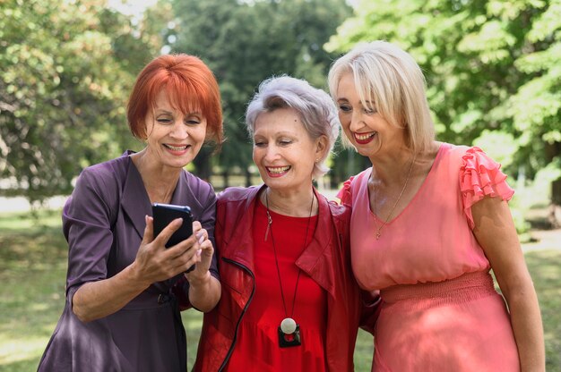 Mujeres mayores que comprueban un teléfono juntos