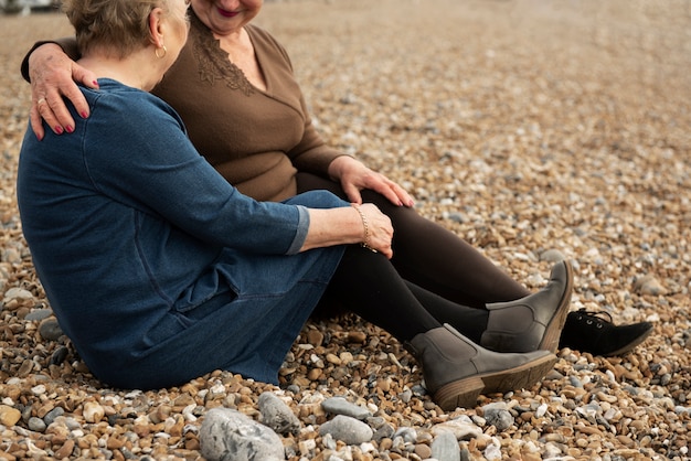 mujeres mayores, sentado, en, playa