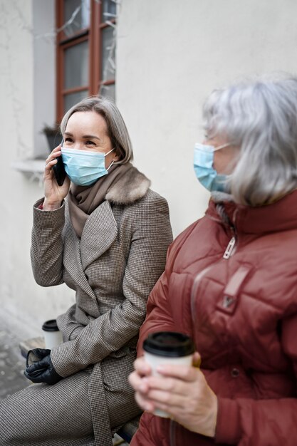 Mujeres mayores de tiro medio con tazas de café.