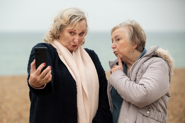 Mujeres mayores de tiro medio tomando selfie