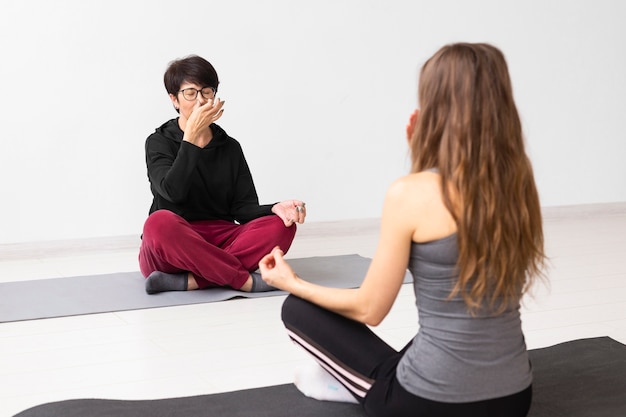 Mujeres meditando y cubriendo una fosa nasal.