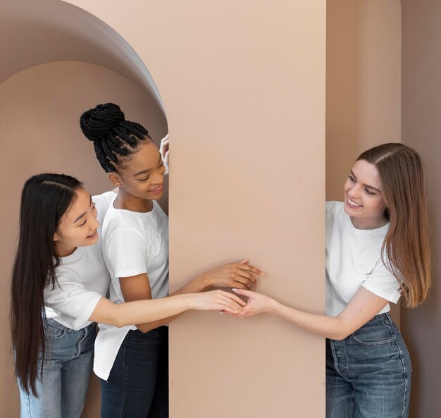 Mujeres multiculturales sonrientes junto a la pared