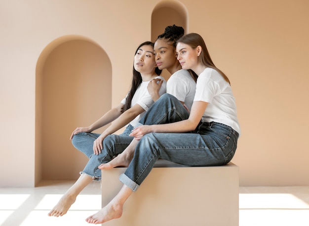 Mujeres multiculturales sonrientes posando tiro completo