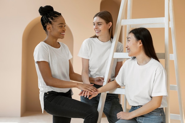 Foto gratuita mujeres multiculturales sonrientes posando tiro medio