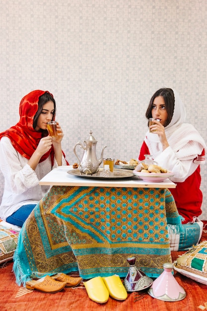 Foto gratuita mujeres musulmanas bebiendo té