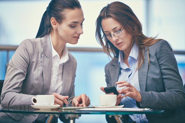 Mujeres de negocio con un teléfono móvil