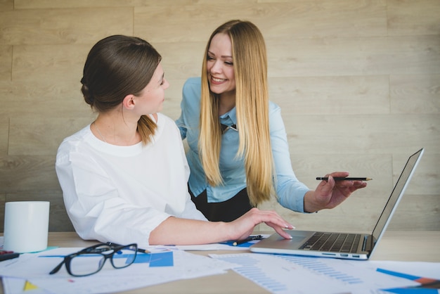 Foto gratuita mujeres de negocios riéndose con portátil