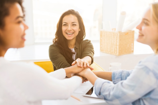 Mujeres de negocios sonrientes estrechándole la mano