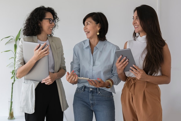 Mujeres de negocios de tiro medio hablando entre sí