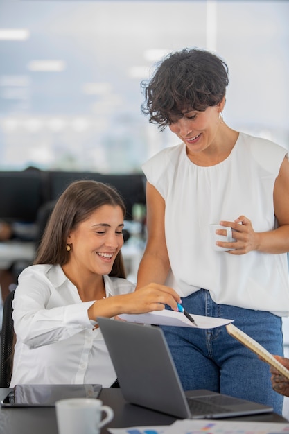 Mujeres de negocios de tiro medio hablando