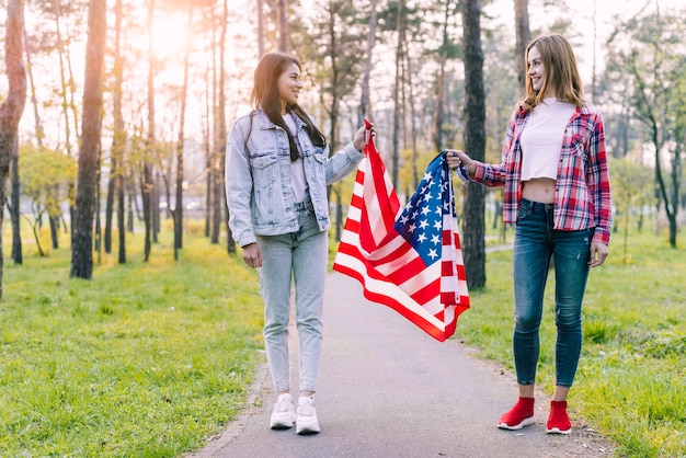 Mujeres en parque con bandera de Estados Unidos.