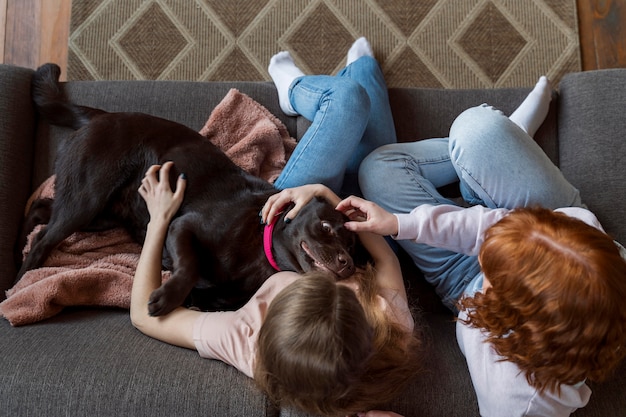 Foto gratuita mujeres y perro tendido en el sofá