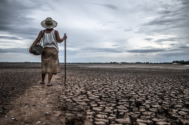 Mujeres de pie en suelo seco y artes de pesca, calentamiento global y crisis del agua