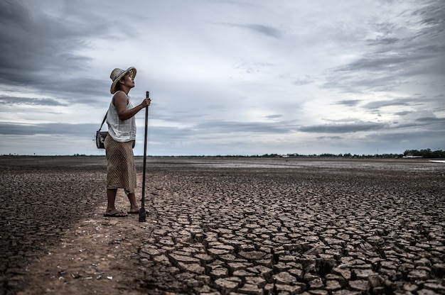 Mujeres de pie en suelo seco y artes de pesca, calentamiento global y crisis del agua