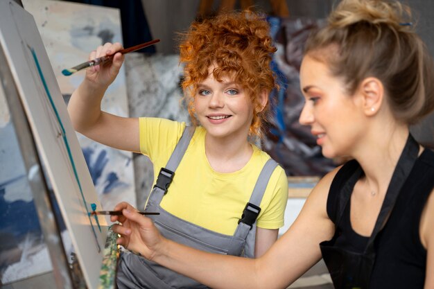 Mujeres pintando sobre lienzo de cerca