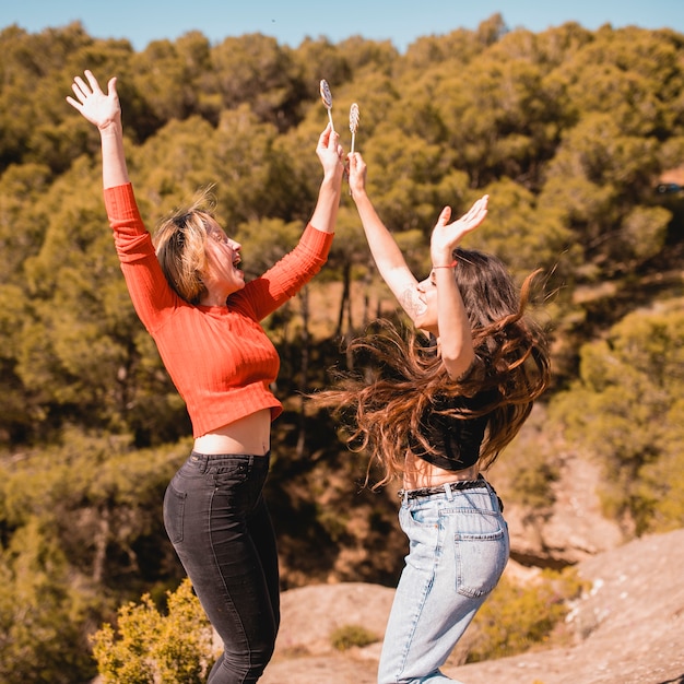 Foto gratuita mujeres con piruletas saltando