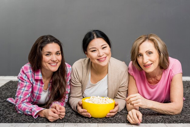 Mujeres en el piso comiendo palomitas de maíz