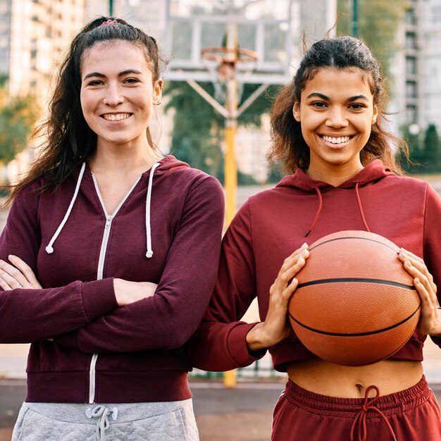 Mujeres posando junto a una pelota de baloncesto