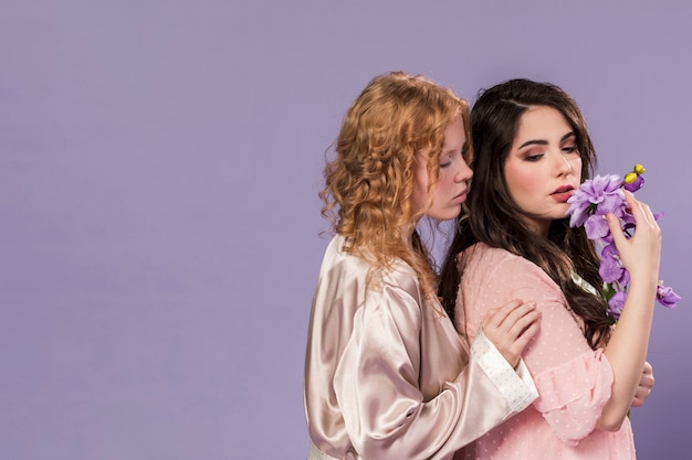 Mujeres posando con ramo de dalia y orquídeas con espacio de copia