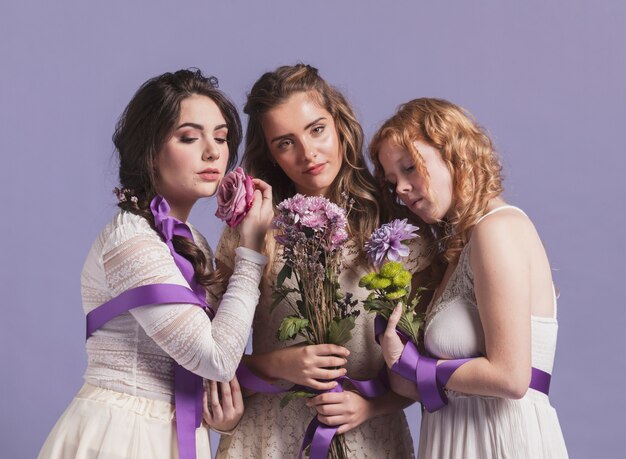 Mujeres posando con ramos de flores