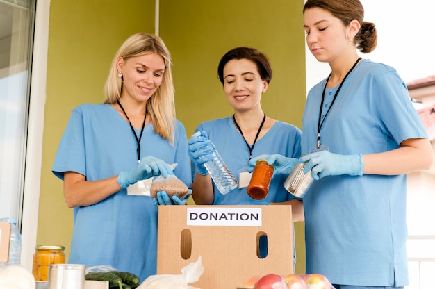 Mujeres preparando caja con donación de alimentos