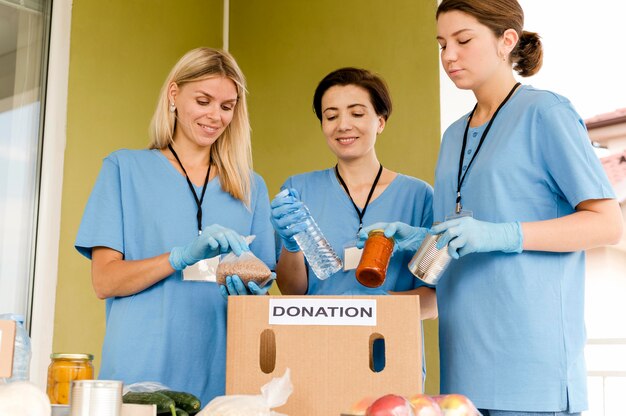 Mujeres preparando caja con donación de alimentos