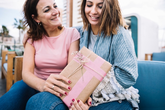 Foto gratuita mujeres con presente en el sofá