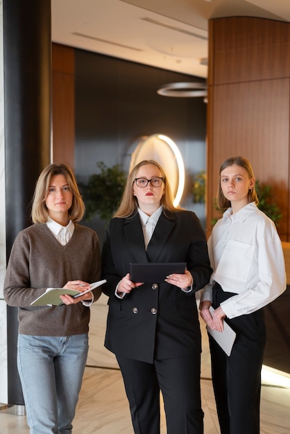 Foto gratuita mujeres profesionales con traje elegante en la oficina con tableta