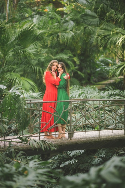 Foto gratuita mujeres en un puente rodeadas de follaje