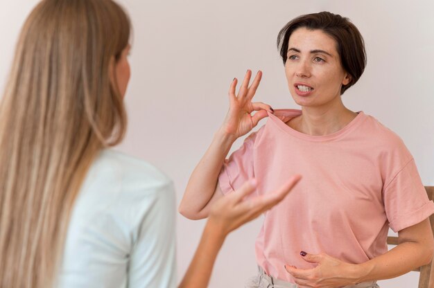 Mujeres que conversan entre sí mediante el lenguaje de señas.