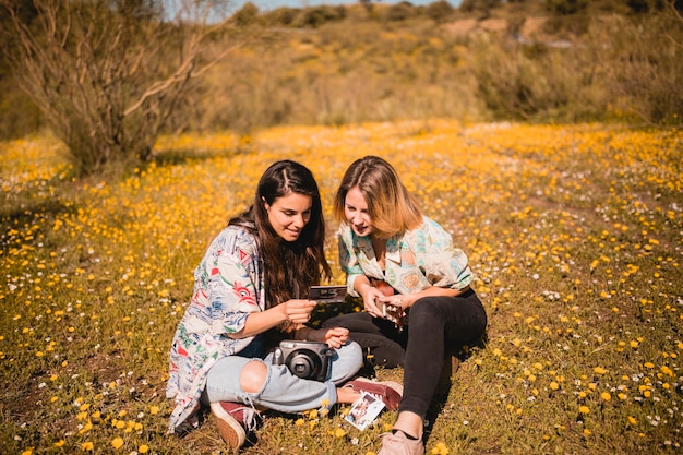 Foto gratuita mujeres que miran la imagen en la tierra del campo