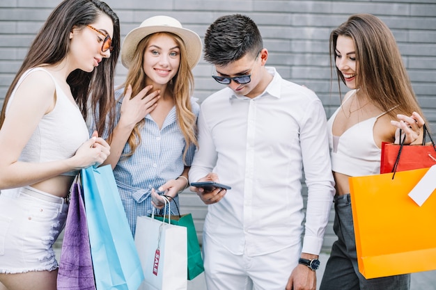 Mujeres que miran el teléfono inteligente del hombre