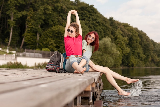 Foto gratuita mujeres que se quedan en el muelle y se divierten