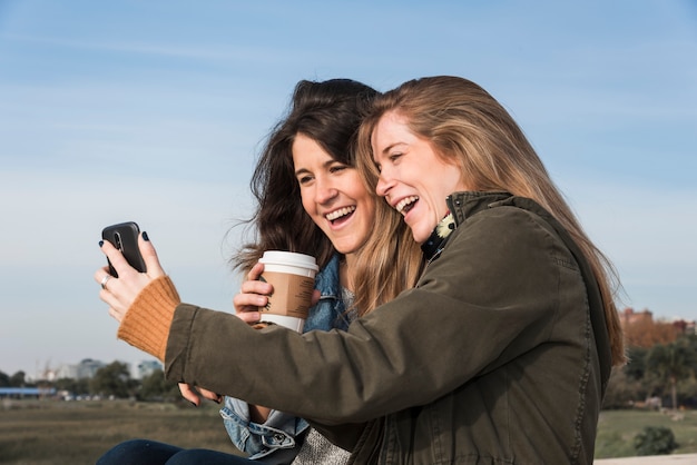 Foto gratuita mujeres que toman selfie en el fondo de la naturaleza