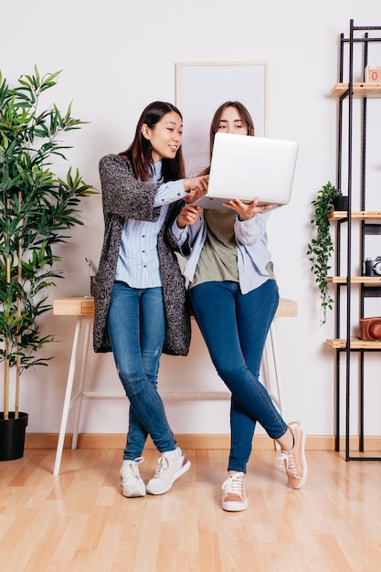 Foto gratuita mujeres que usan la computadora portátil mientras coworking